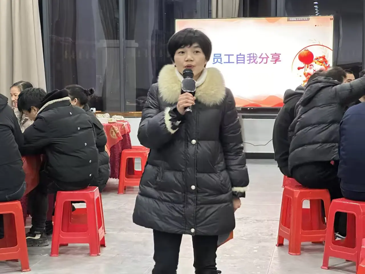 A Wangong employee speaks into the microphone during the employee self-sharing session at the annual company gathering.